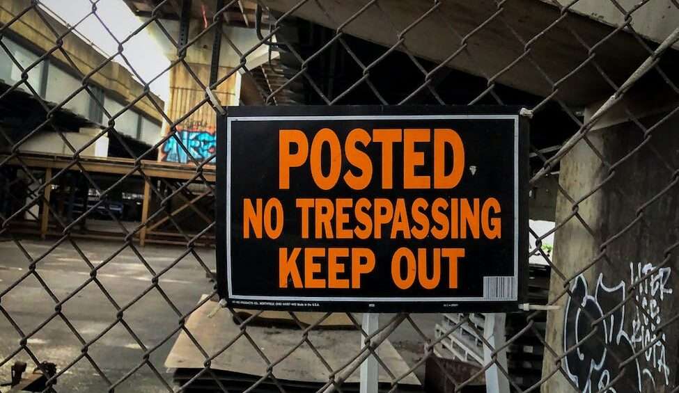 a signage hanging on a chain link fence